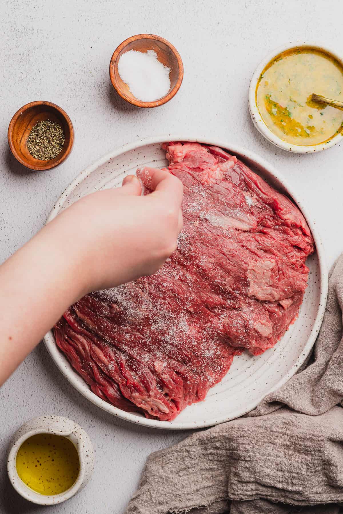 hand seasoning bavette steak very well with salt and pepper.