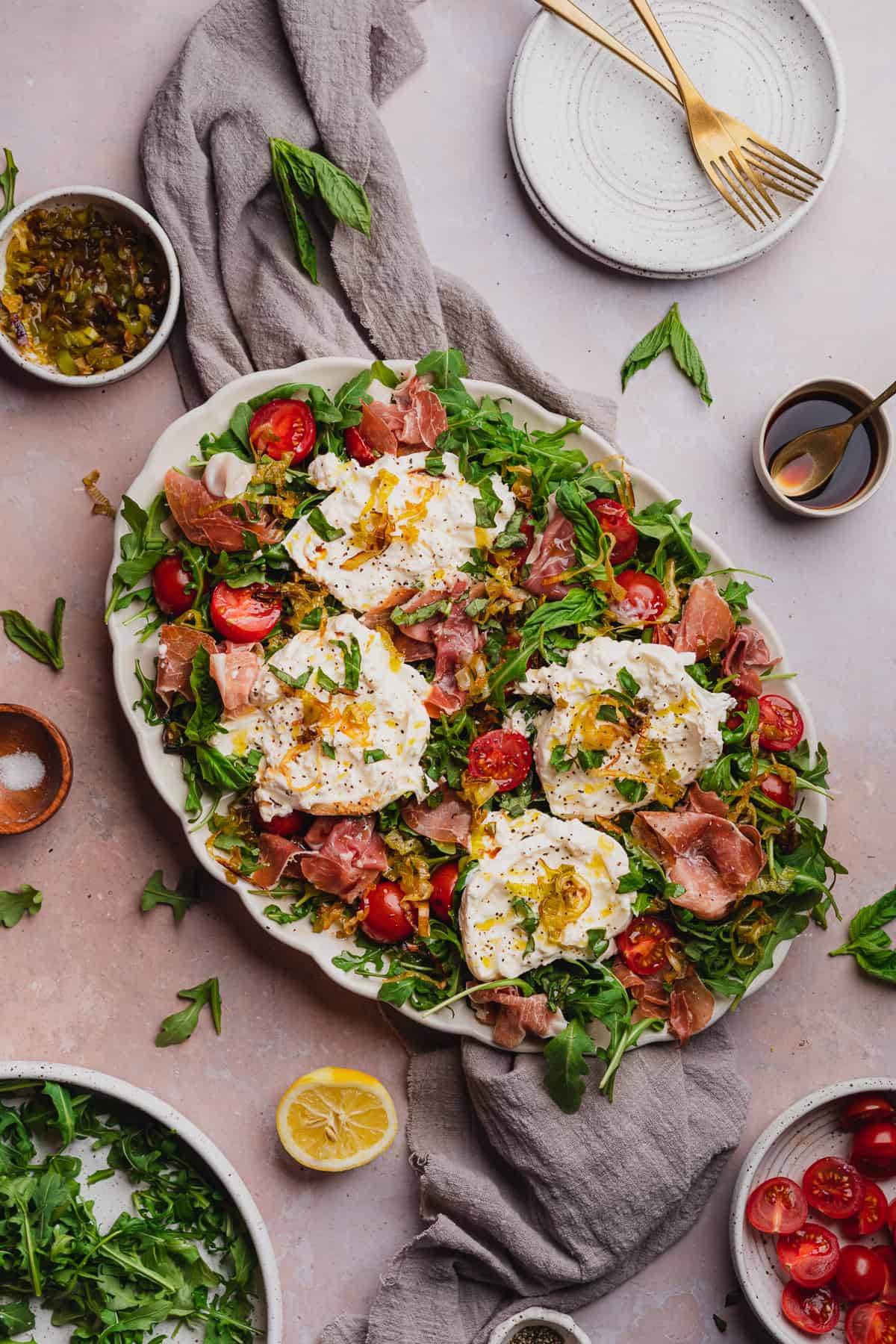 burrata and prosciutto arugula salad with ripe tomatoes, basil, lemon and fried leeks 