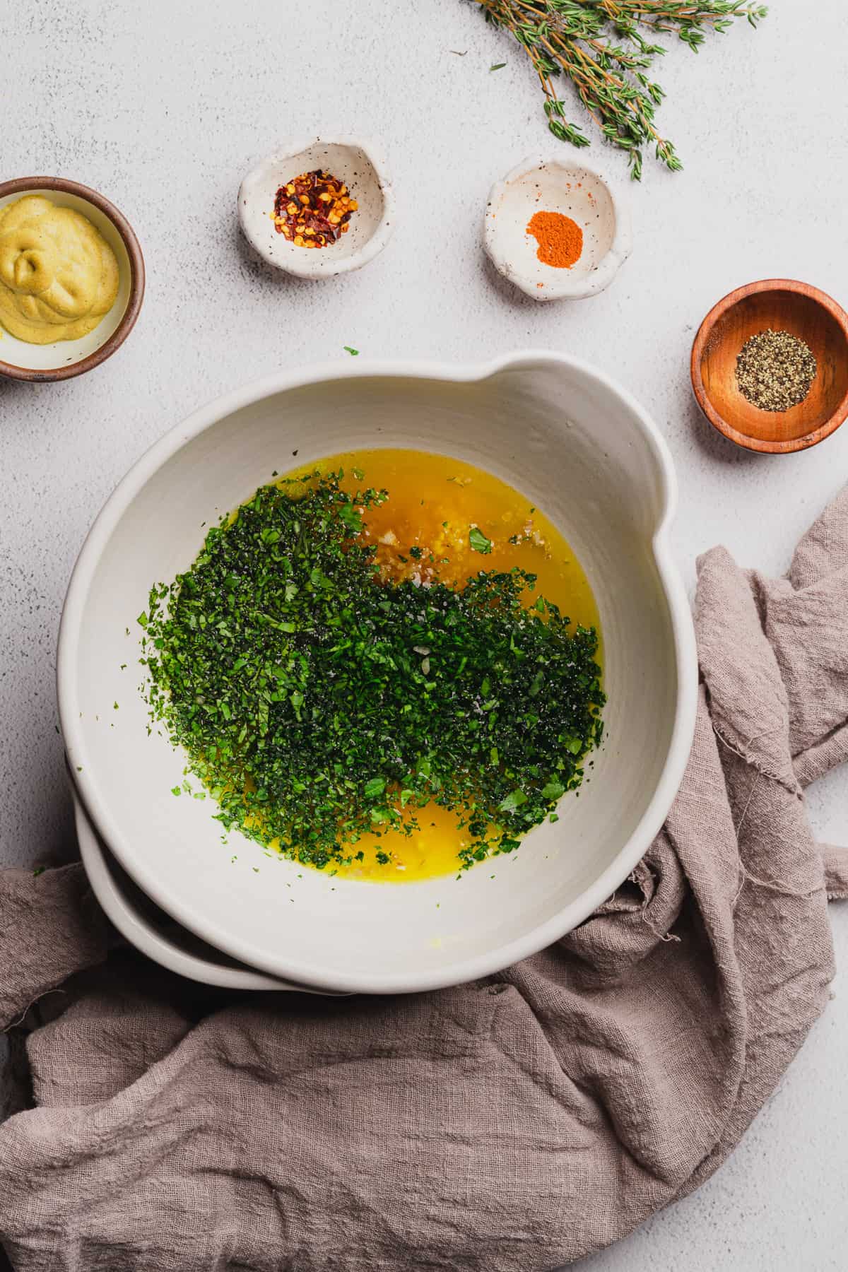 melted butter with parsley, cilantro, chives, and thyme in a bowl. 