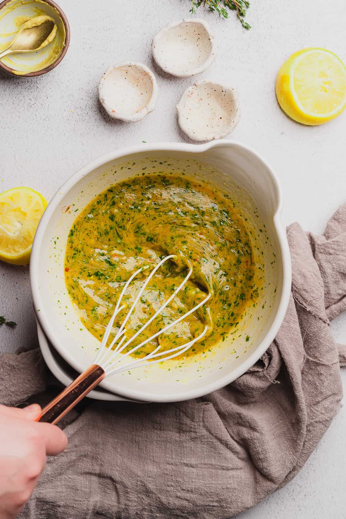 whisking together melted butter with herbs, lemon, spices, shallots, and garlic. 