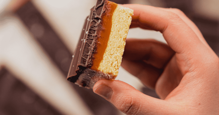 Gluten Free Caramel Slice held in a hand from a top down view