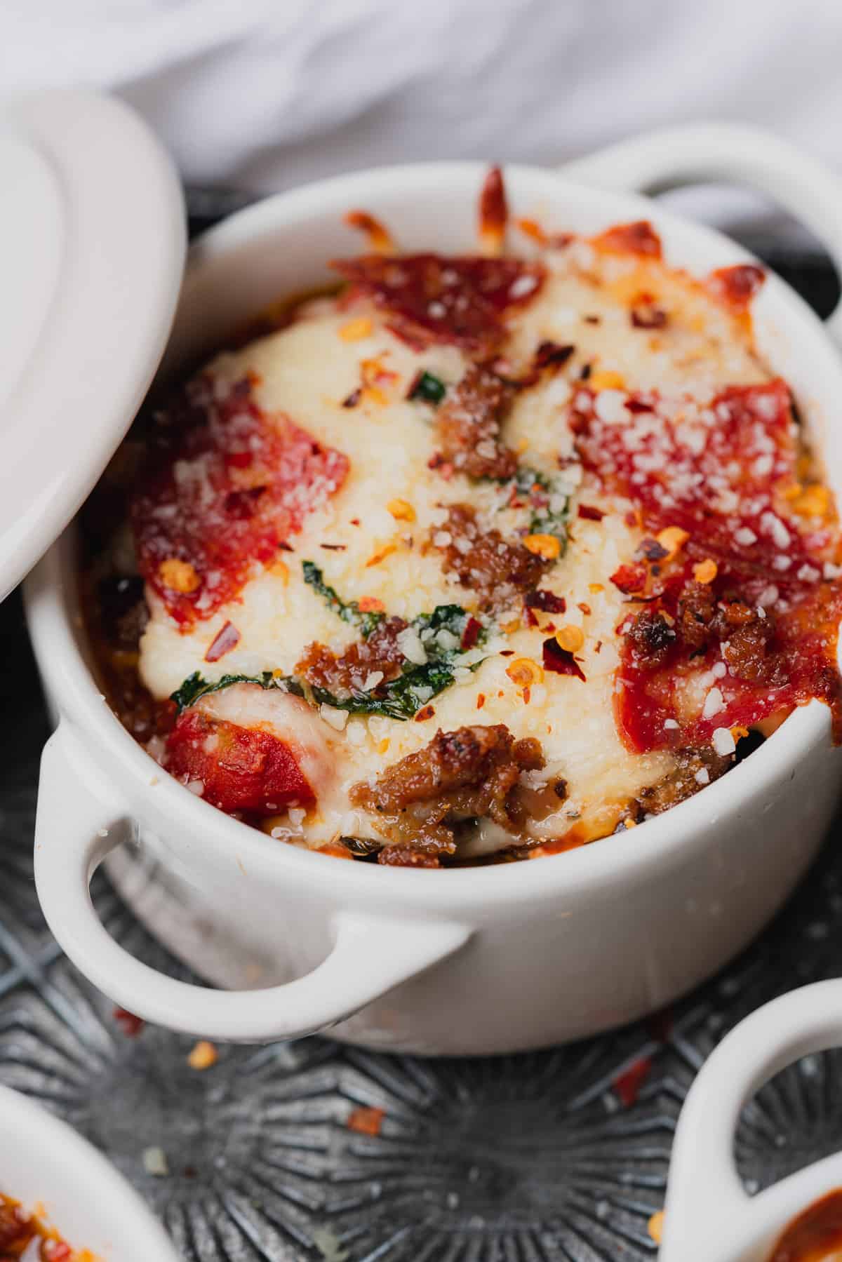 close up shot of a cocotte filled pizza bowl with the top off. 