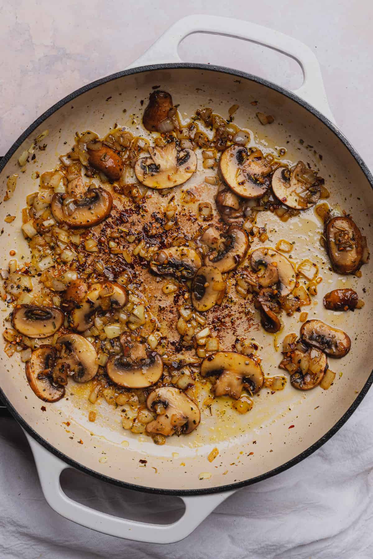 mushrooms and onions cooked in a skillet with olive oil and seasonings. 