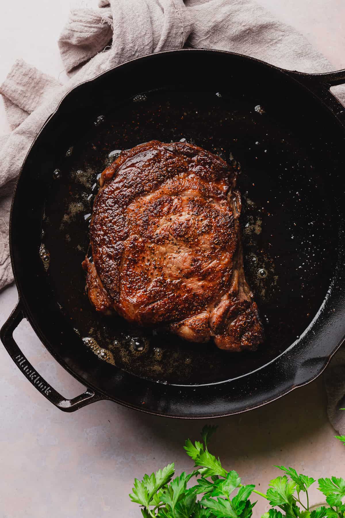 ribeye steak seared in a cast iron skillet.