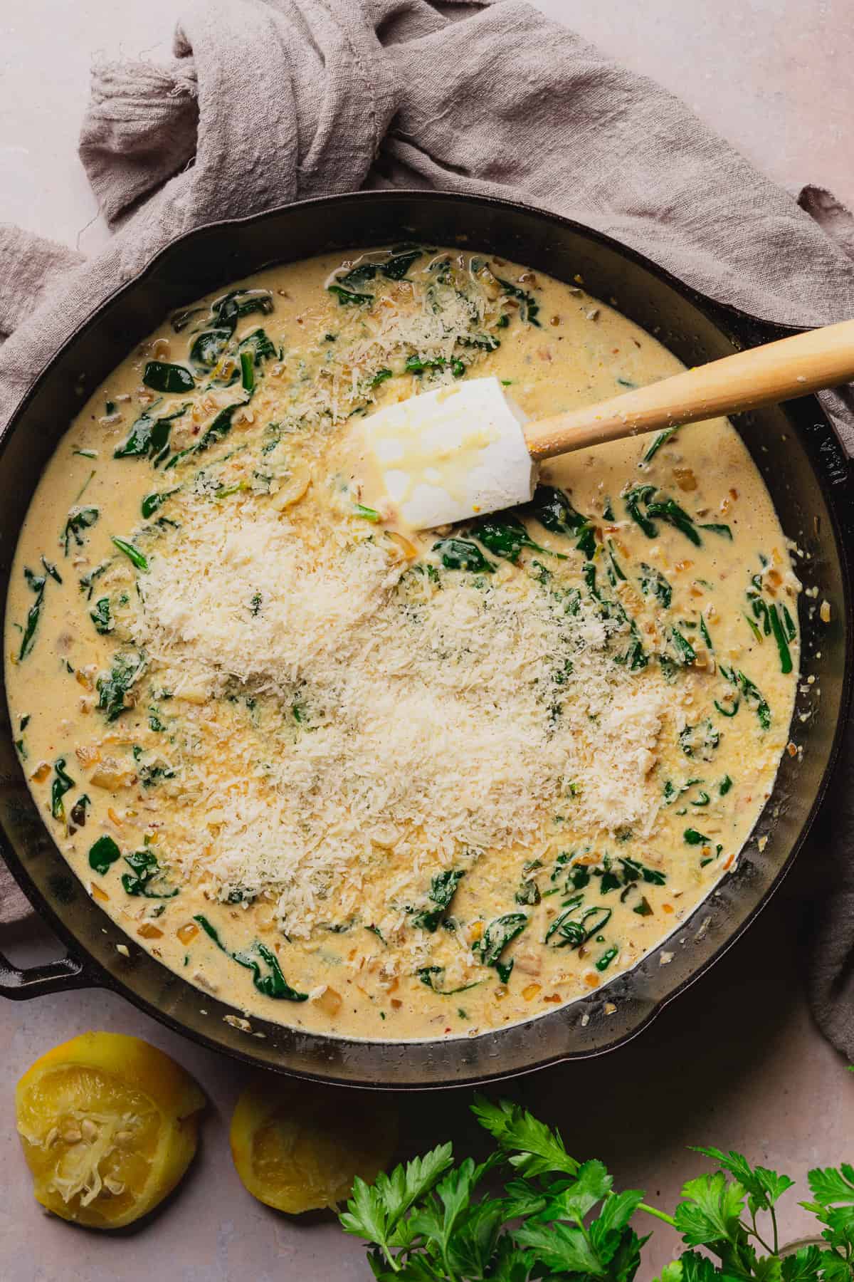 creamy sauce with spinach and fresh parmesan added with a rubber spatula in the skillet to stir. 