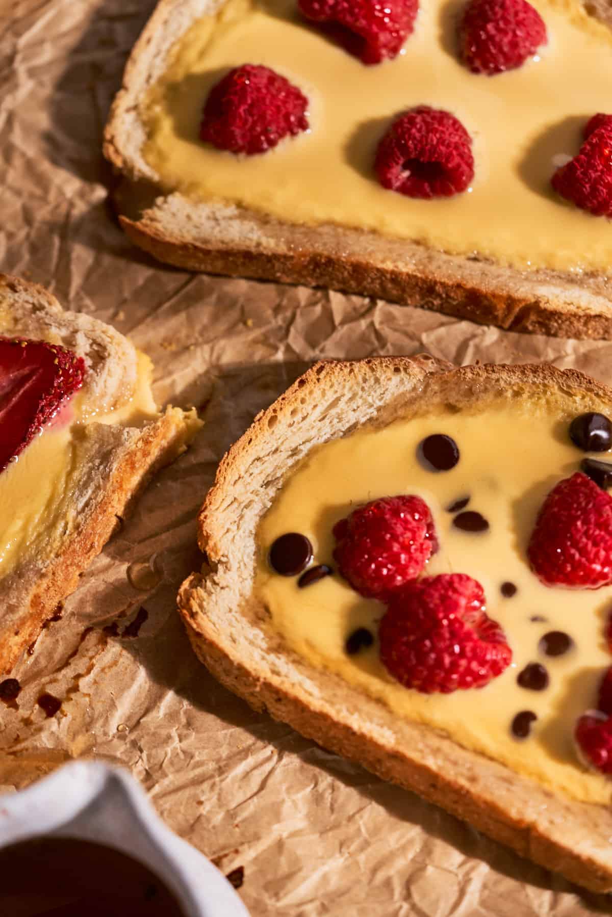 very close up shot of sourdough bread filled with baked yogurt custard with fruit and chocolate chips. 