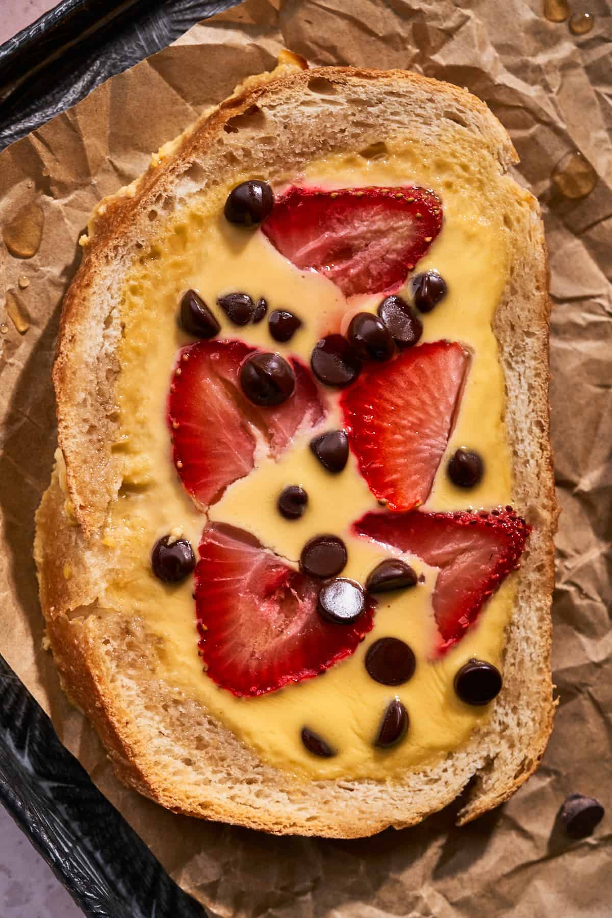 close up shot of tiktok custard yogurt toast with strawberries and chocolate chips.