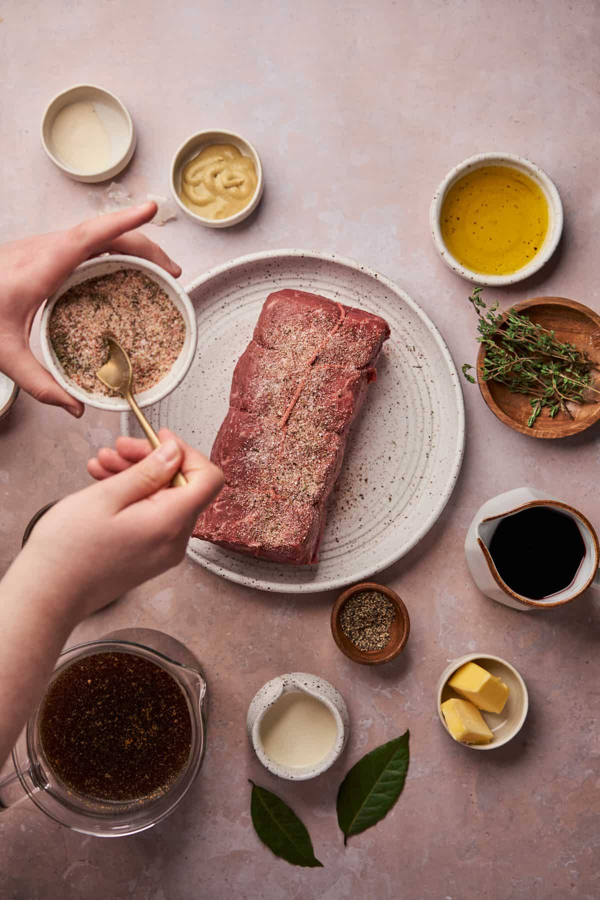 hand creating a seasoning mixture and sprinkling it all over a beef roast. 