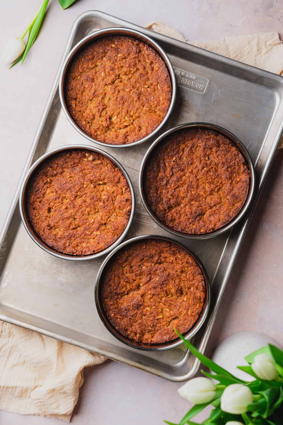 Baked keto carrot cakes in pans on a baking sheet. 