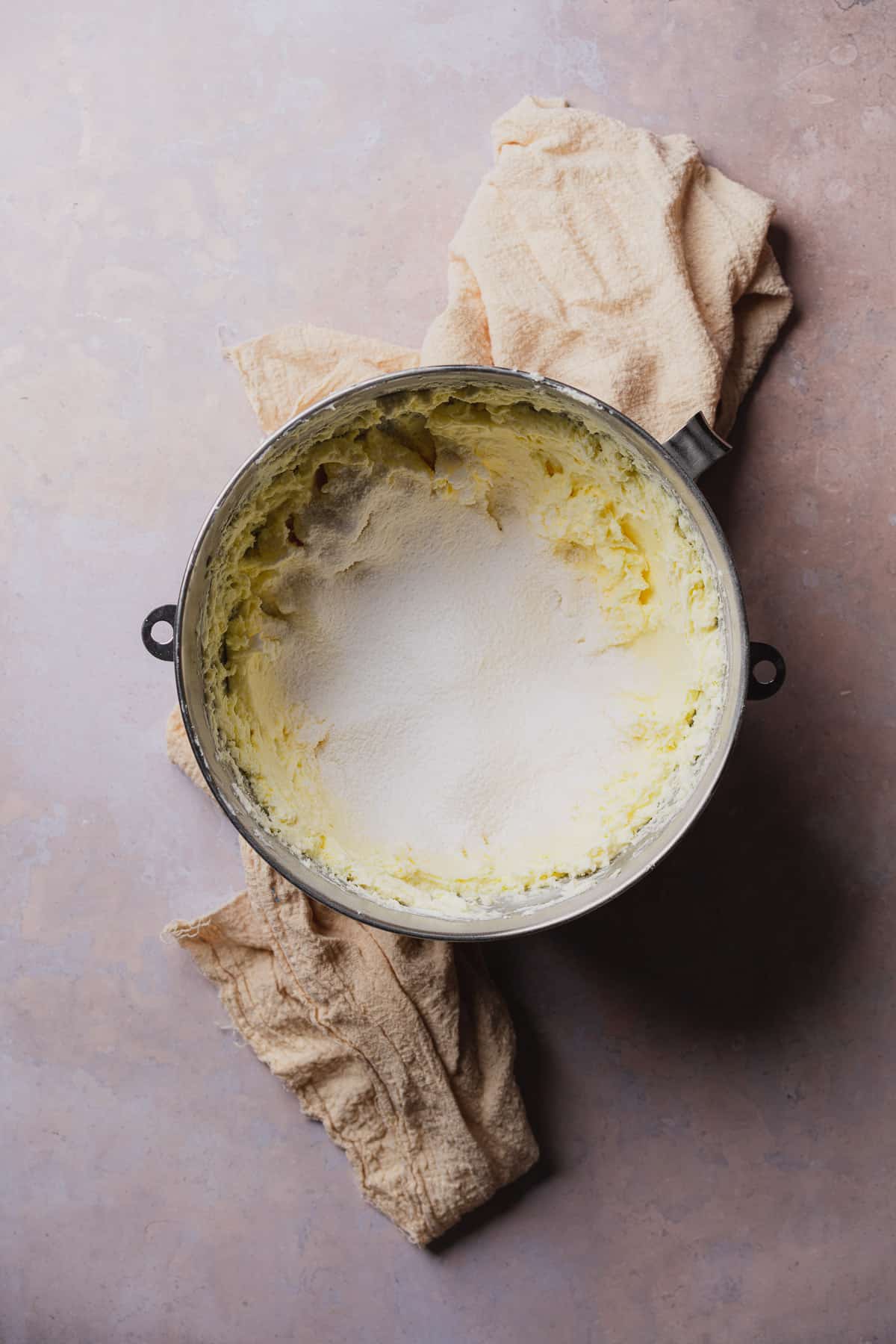 powdered sweetener in a mixing bowl with cream cheese frosting and butter.  