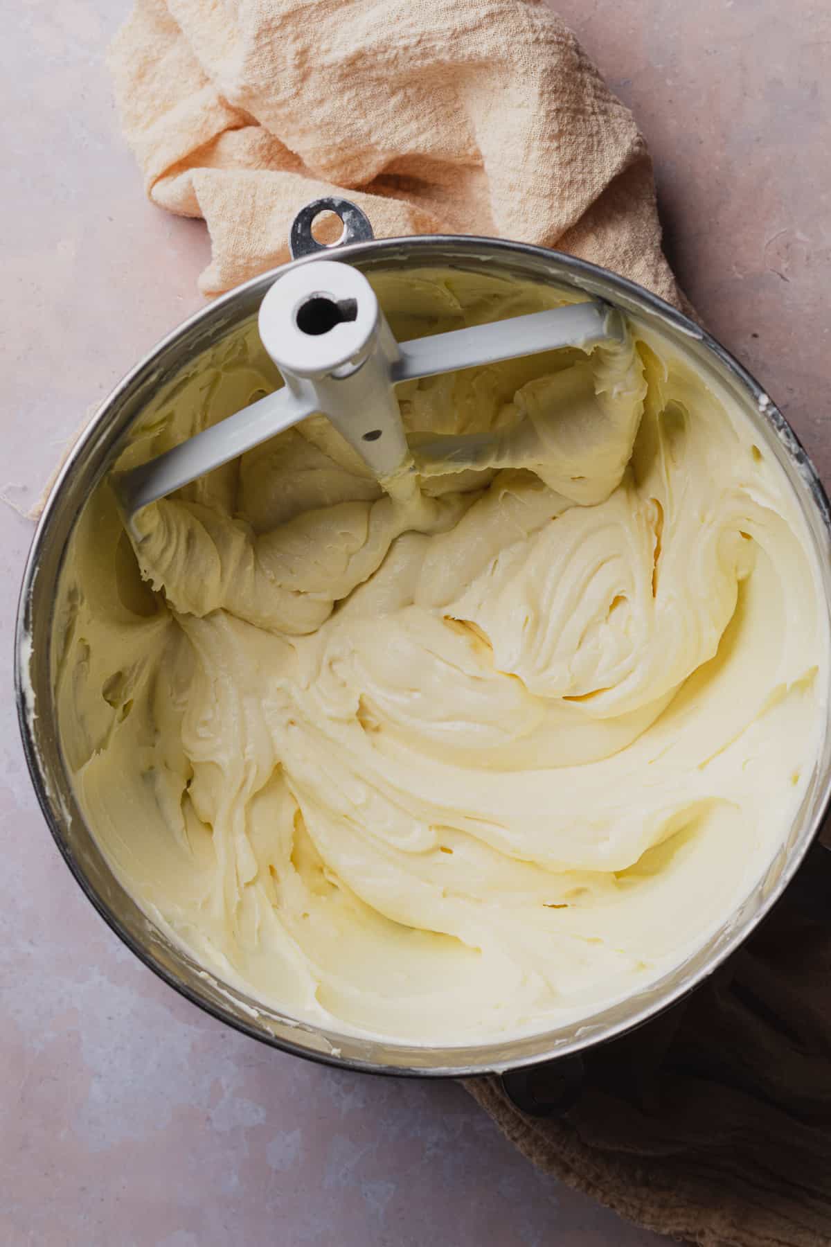 delicious, silky smooth keto cream cheese frosting in a stand mixer bowl with a paddle attachment.