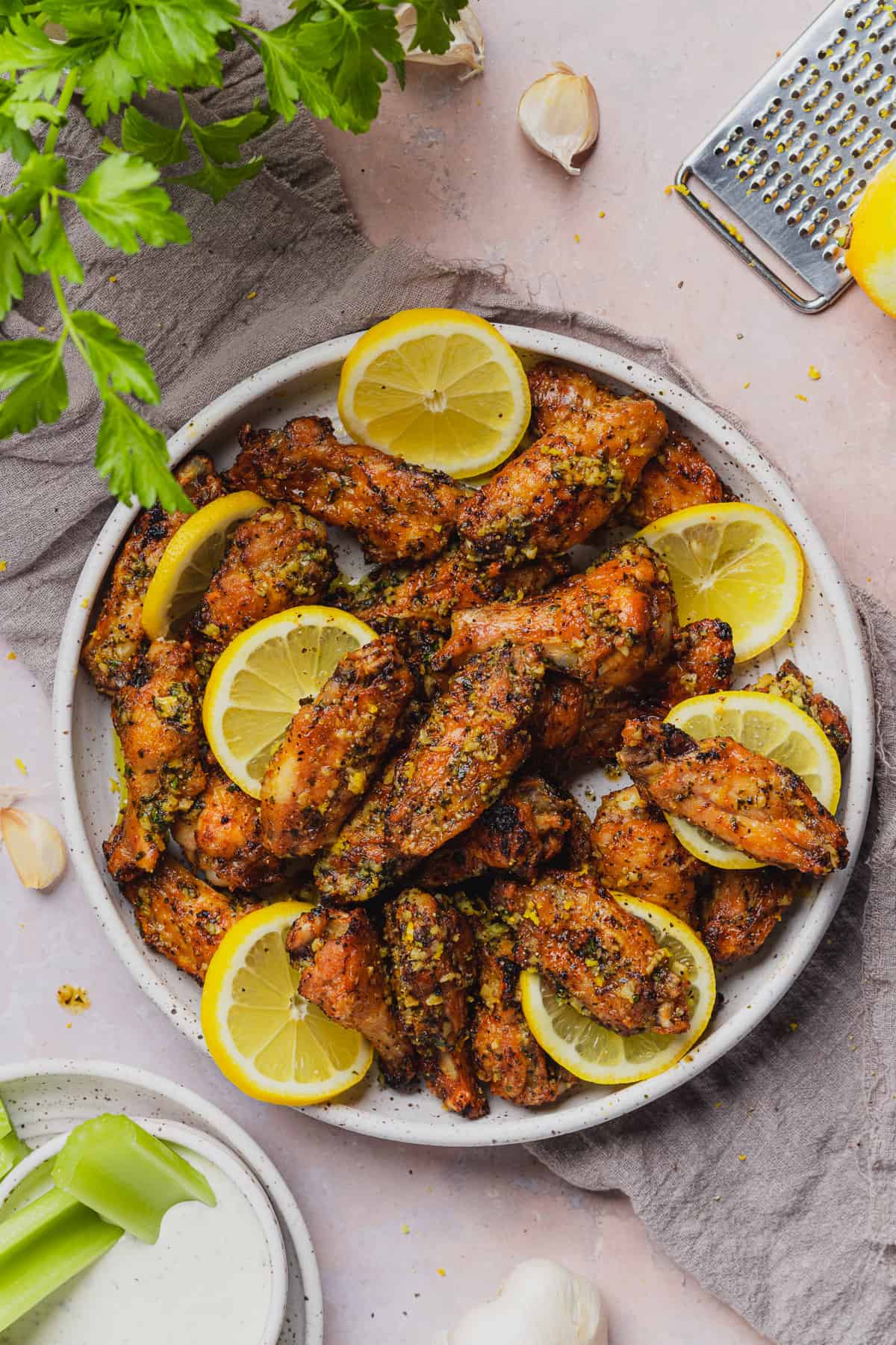 air fryer lemon pepper wings with lemon slices and parsley on the plate. 