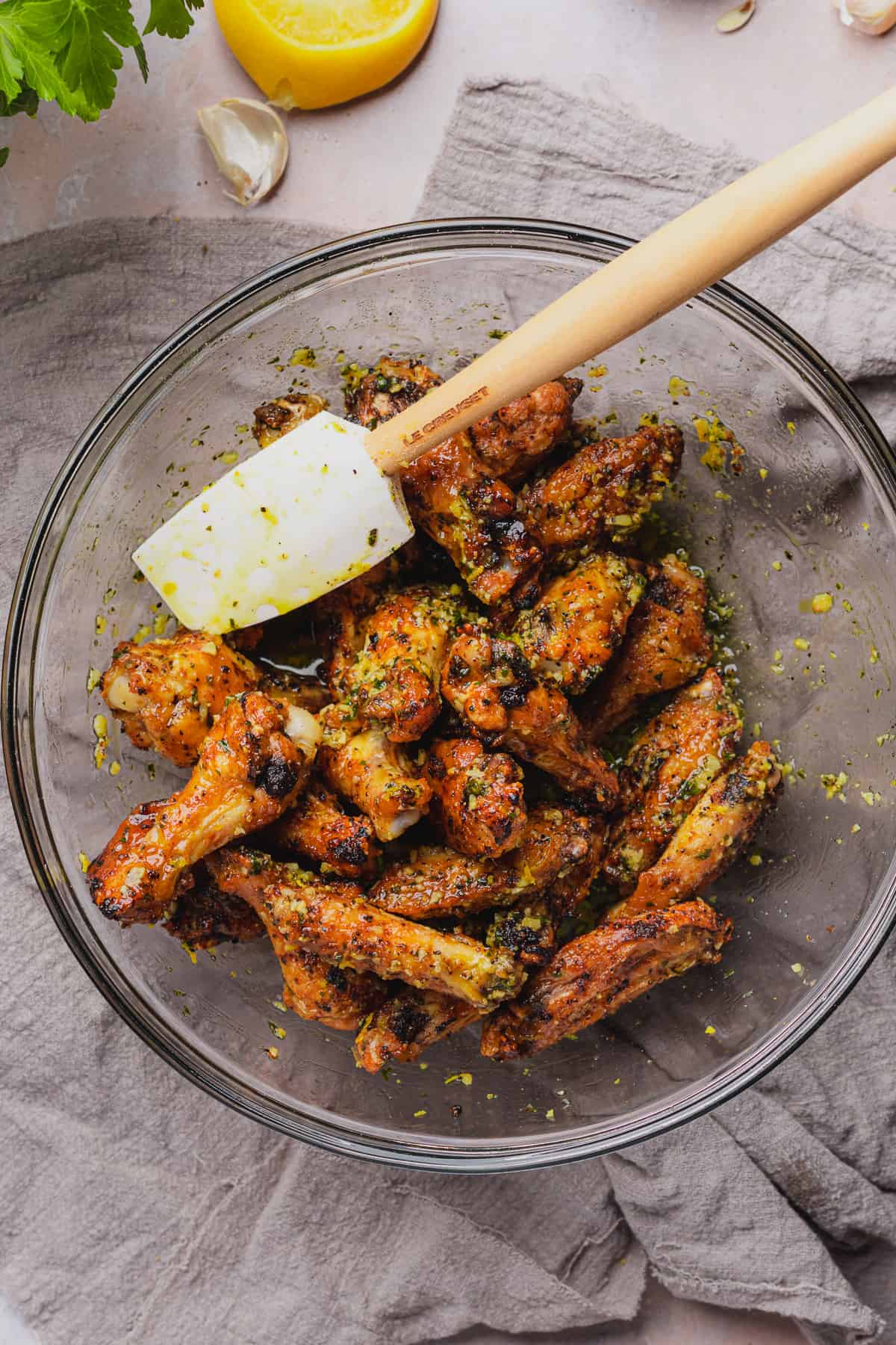 tossing crispy chicken wings with lemon zest, and buttery garlic sauce with parsley. 