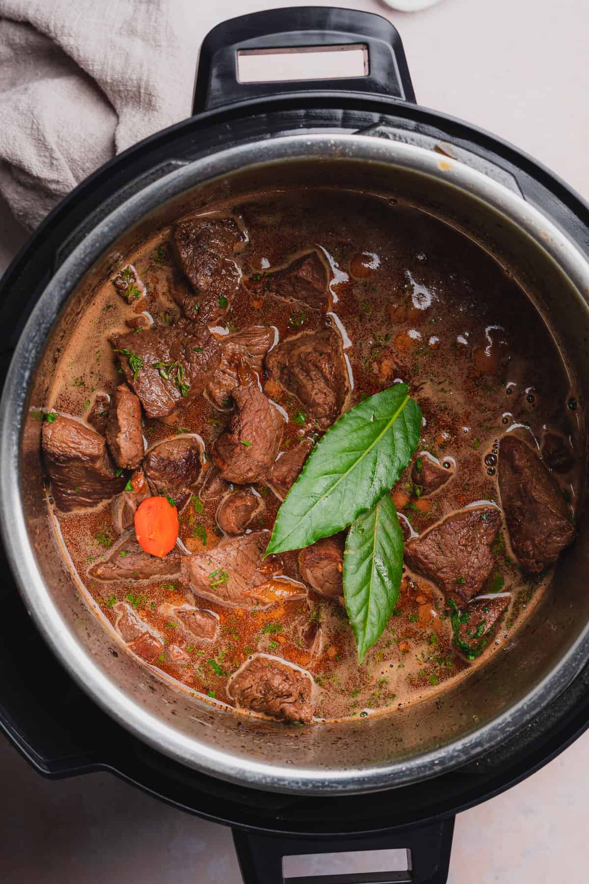 bay leaves on top of beef bourguignon mixture in an instant pot.