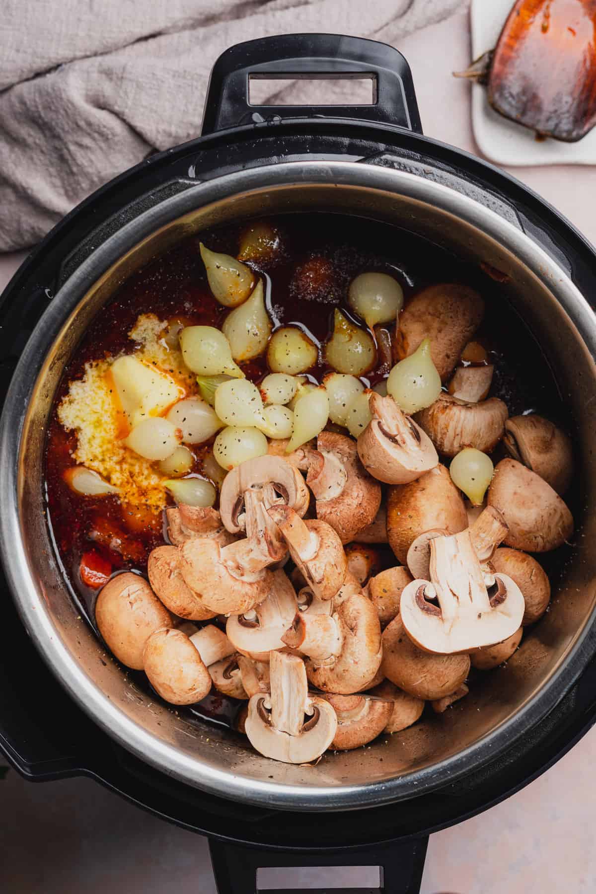 raw mushrooms and pearl onions in a pressure cooker. 