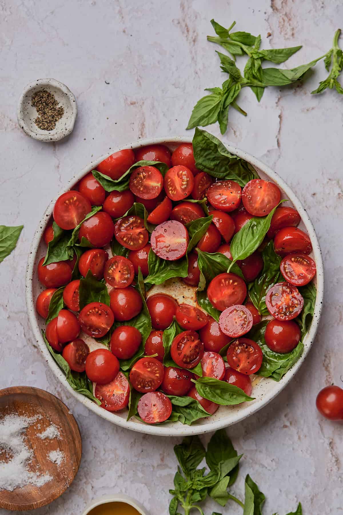 seasoned tomatoes and fresh basil on a plate. 