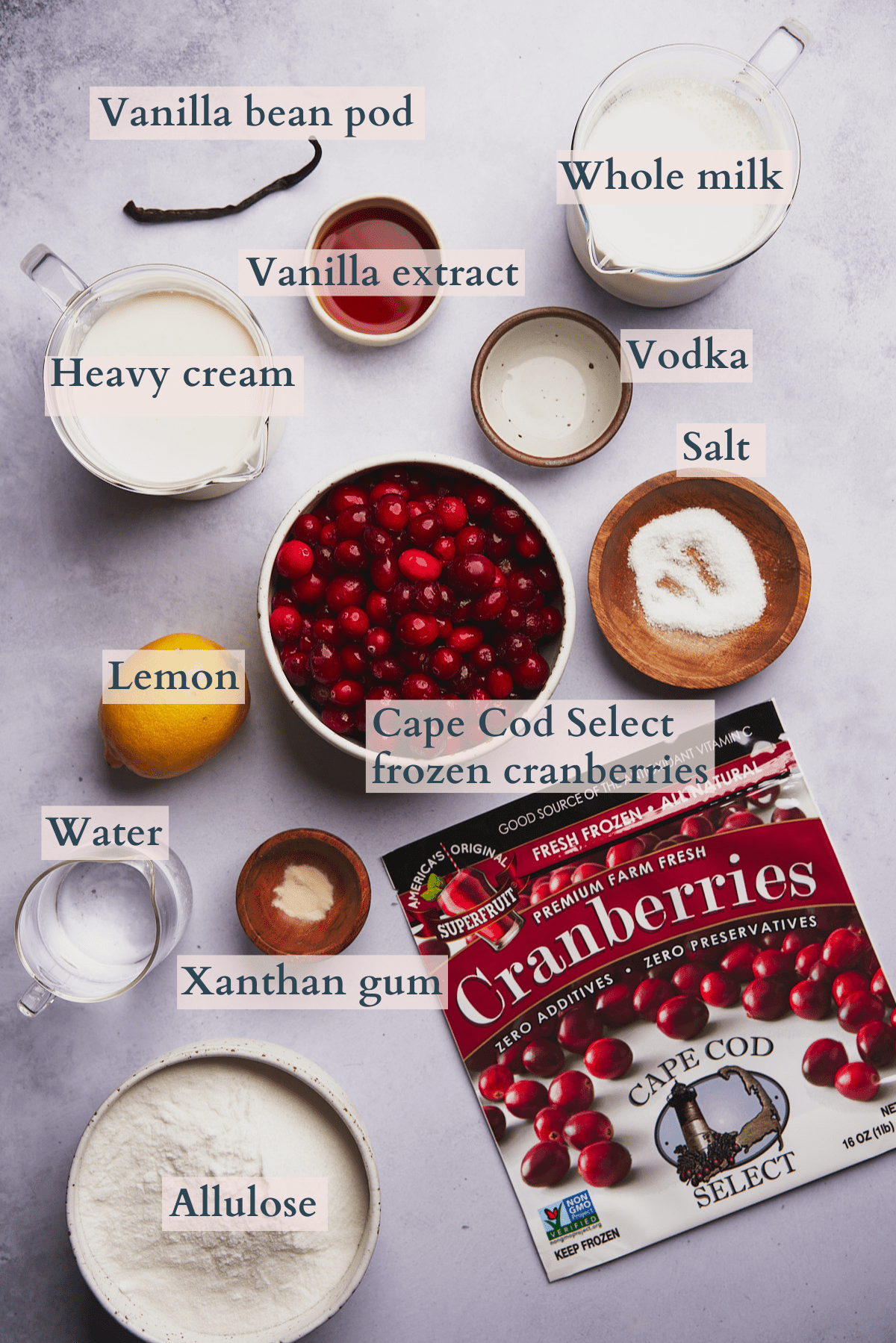 ingredients to make cranberry ice cream with frozen cranberries, allulose sweetener, lemon, milk heavy cream, vanilla extract, xanthan gum, kosher salt, water, vodka, and vanilla bean pods. 