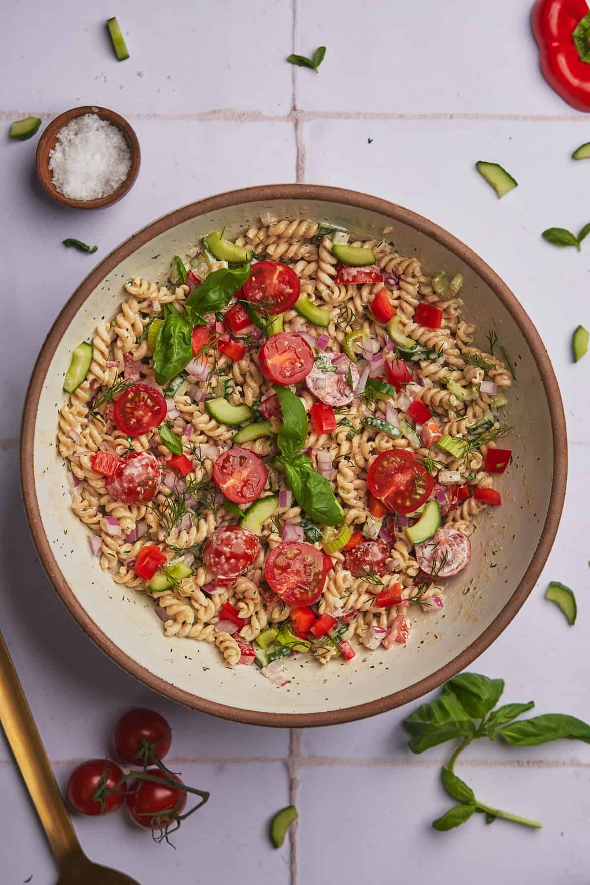 fresh herbs vegetables in a bowl of freshly made pasta salad. 