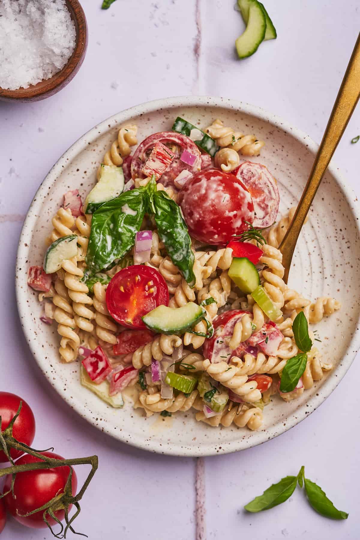 delicious creamy pasta salad with tomatoes, basil, cucumbers and rotini noodles. 