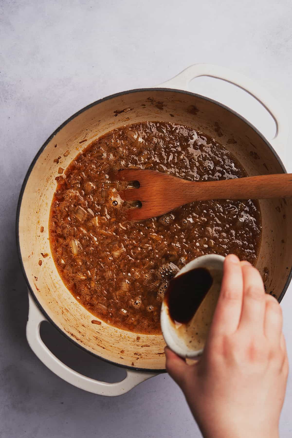 hand pouring Worcestershire sauce. 