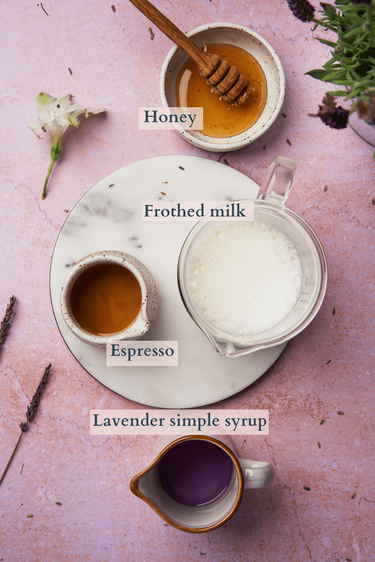 honey lavender latte ingredients, including frothed milk, lavender simple syrup, espresso, and honey. 