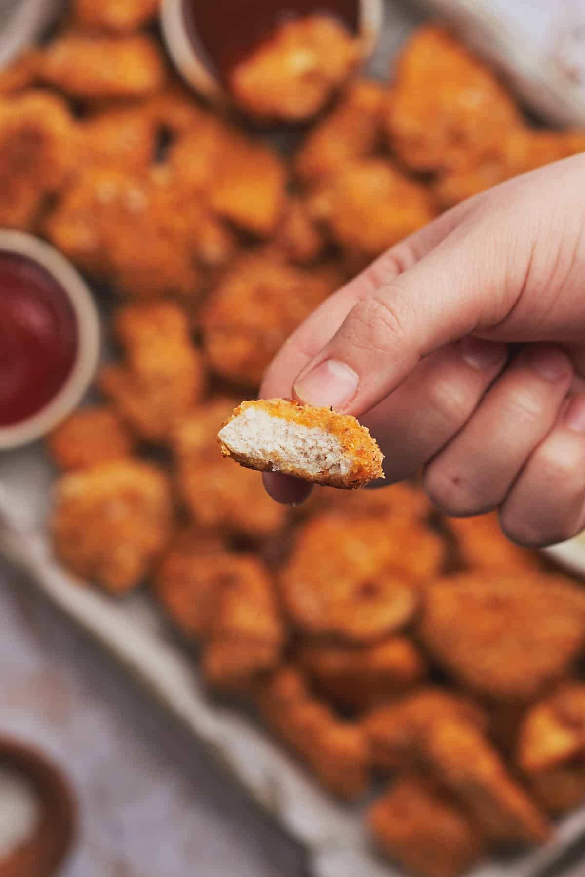 hand showing the inside texture of a keto chicken nugget. 