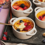keto creme brulee recipe topped with berries and a spoon broken inside