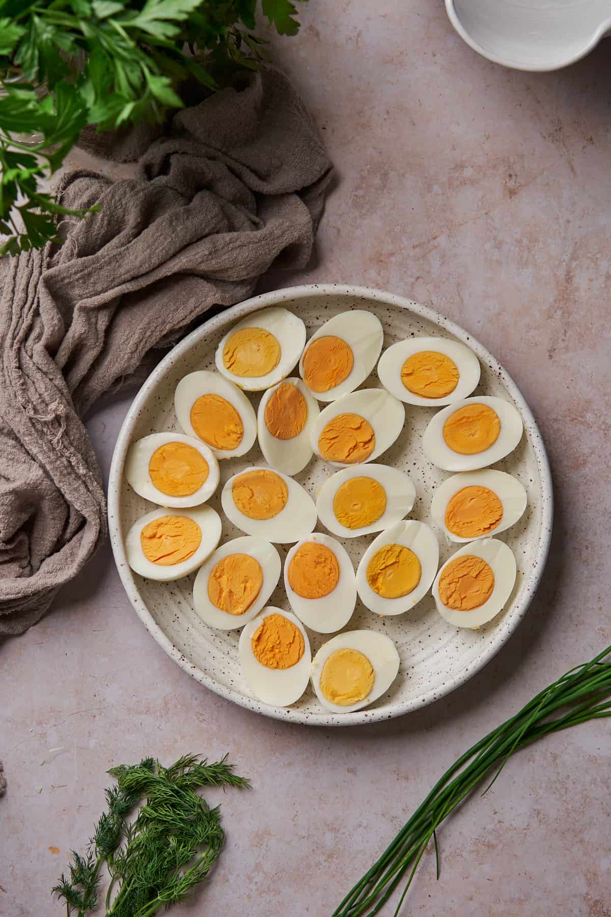 hard boiled eggs cut in half lengthwise with the yolks in tact on a plate. 