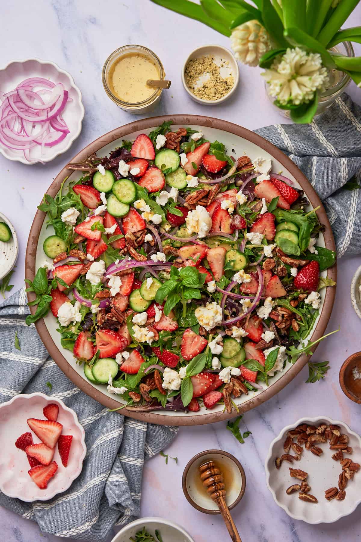 stunning and bright strawberry goat cheese salad with goat hceese, red onions, pecans, hemp hearts and basil.