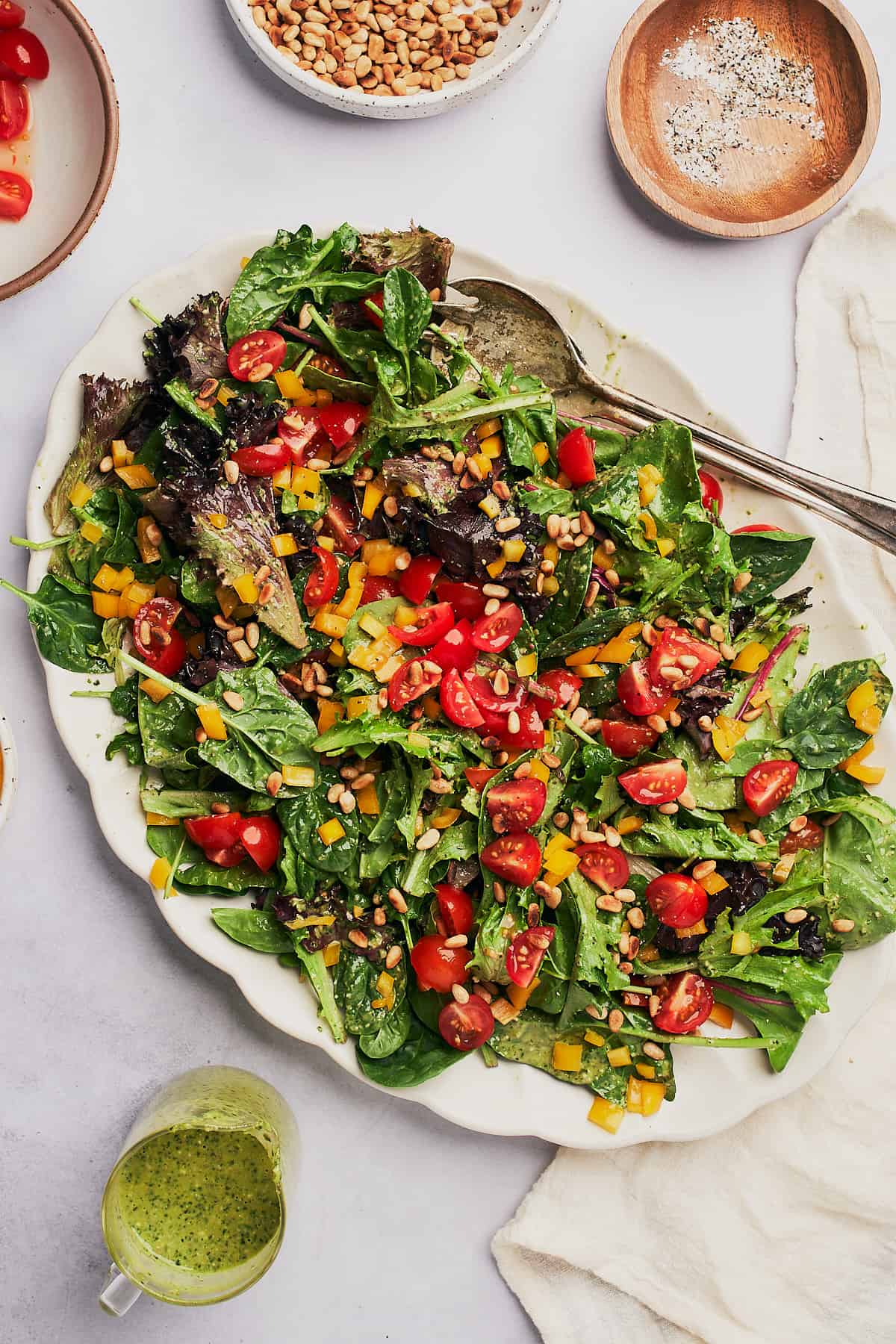 leafy greens topped with fresh chopped tomatoes, yellow bell pepper, and pine nuts. 