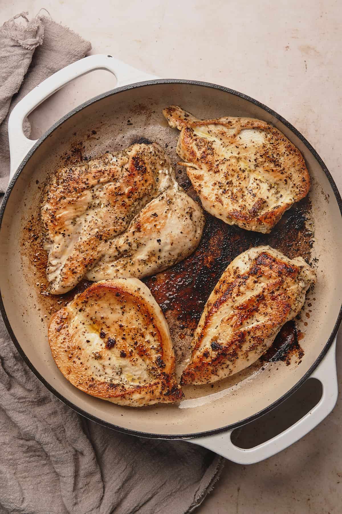 cooked chicken breasts in an enameled cast iron skillet.