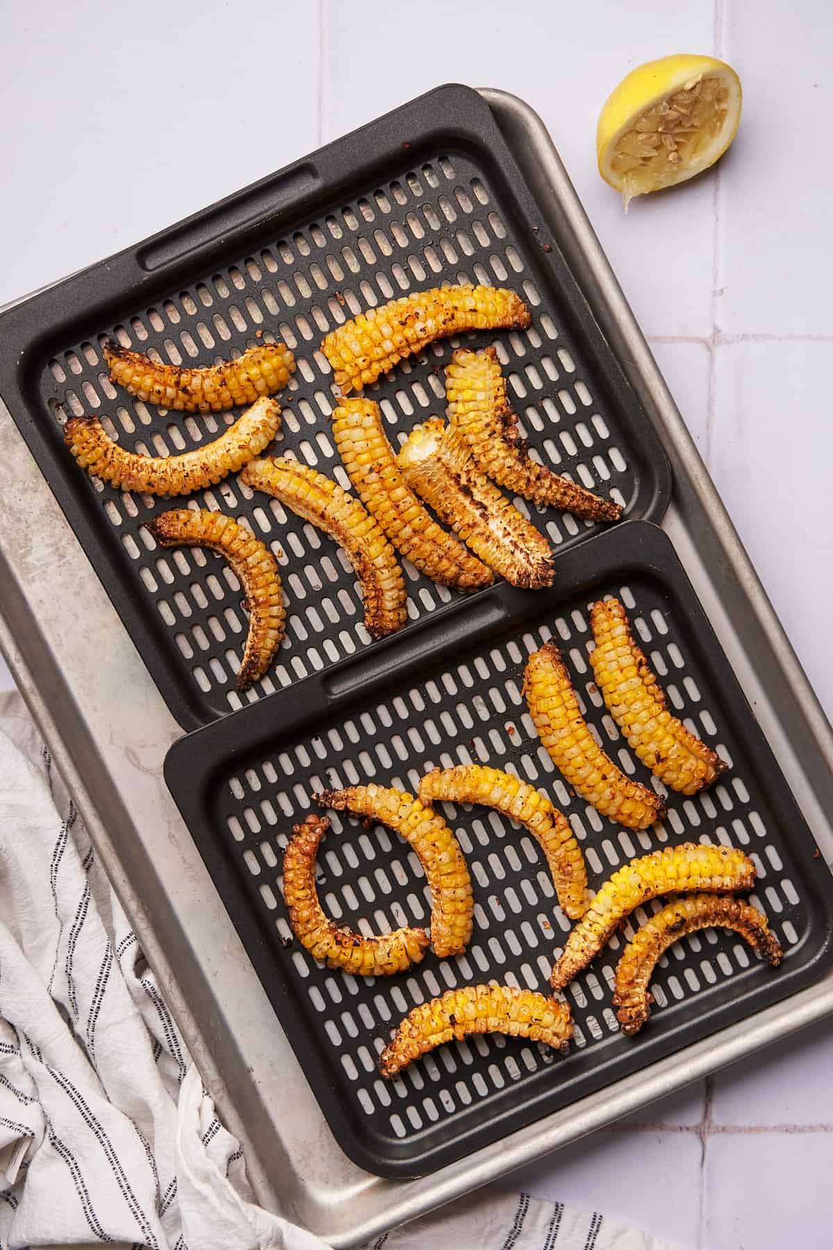 corn ribs curled up on air fryer trays. 