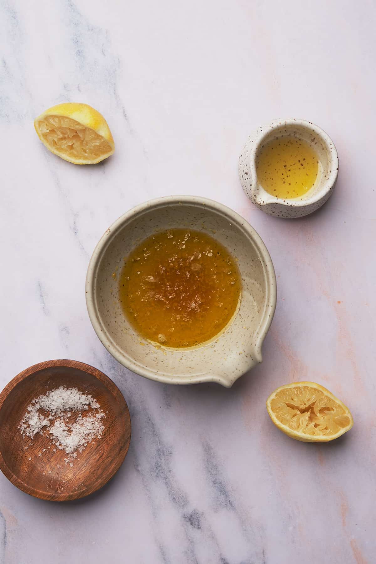 small bowl with olive oil, lemon juice and zest, honey, and salt inside. 