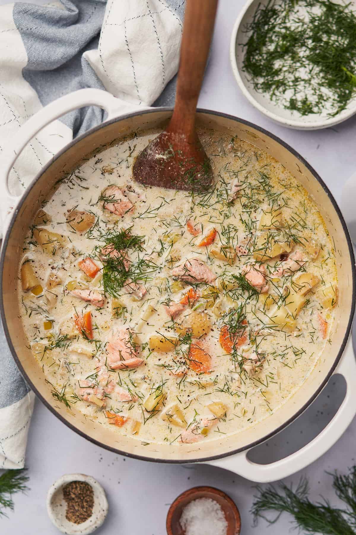 creamy salmon soup in a cast iron dutch oven topped with lots of fresh dill. 