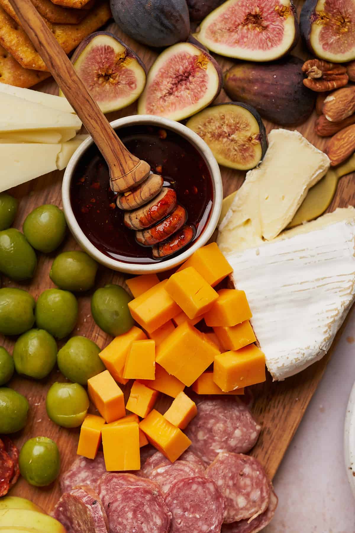 sharp cheddar, castellano olives, brie cheese, figs, manchego, hot honey, and salami bites.
