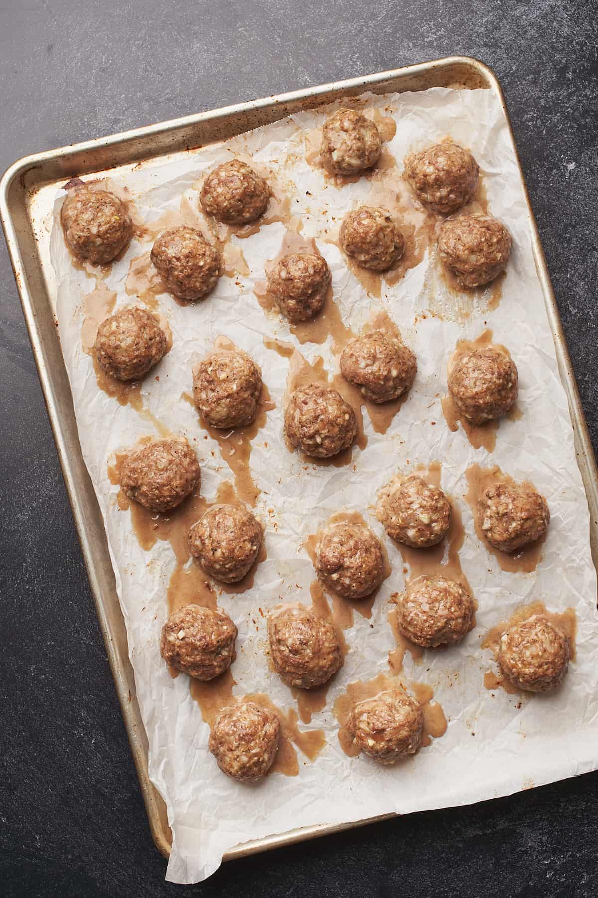 baked meatballs on a baking sheet with parchment paper. 