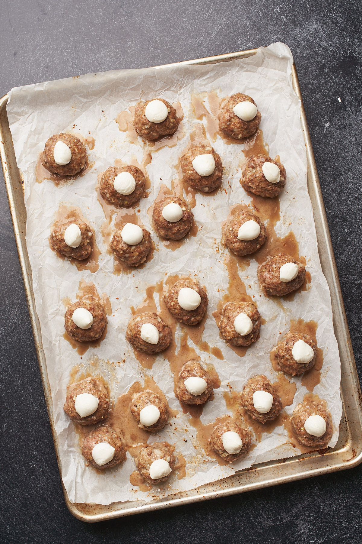 mozzarella cheese on top of meatballs.  