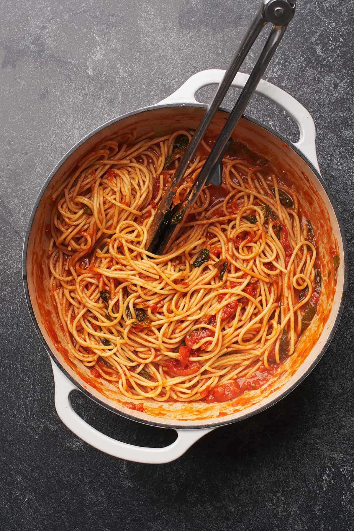 spaghetti tossed in sauce in a dutch oven. 