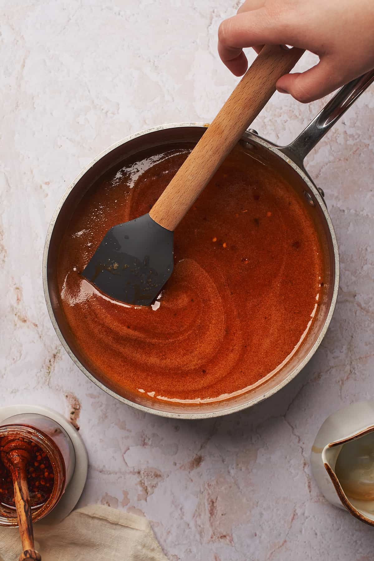 rubber spatula in a  saucepan full of buttery hot honey sauce. 