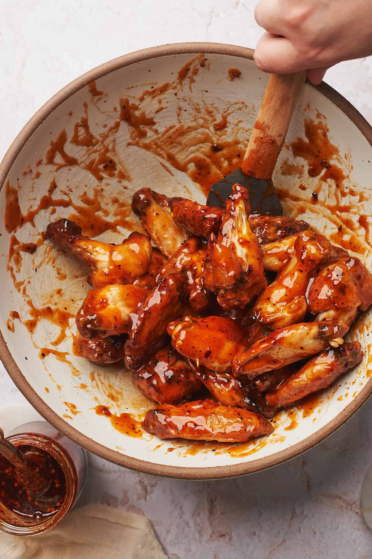 chicken wings in a large bowl coated with hot honey sauce. 