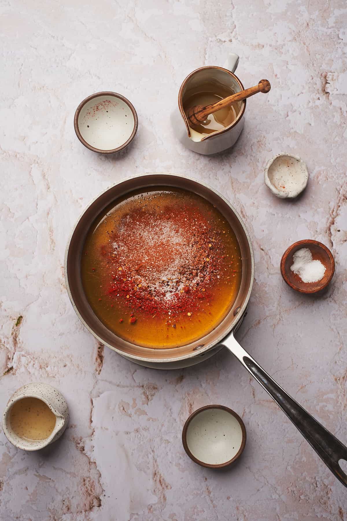 adding in dry seasonings to a saucepan with honey. 