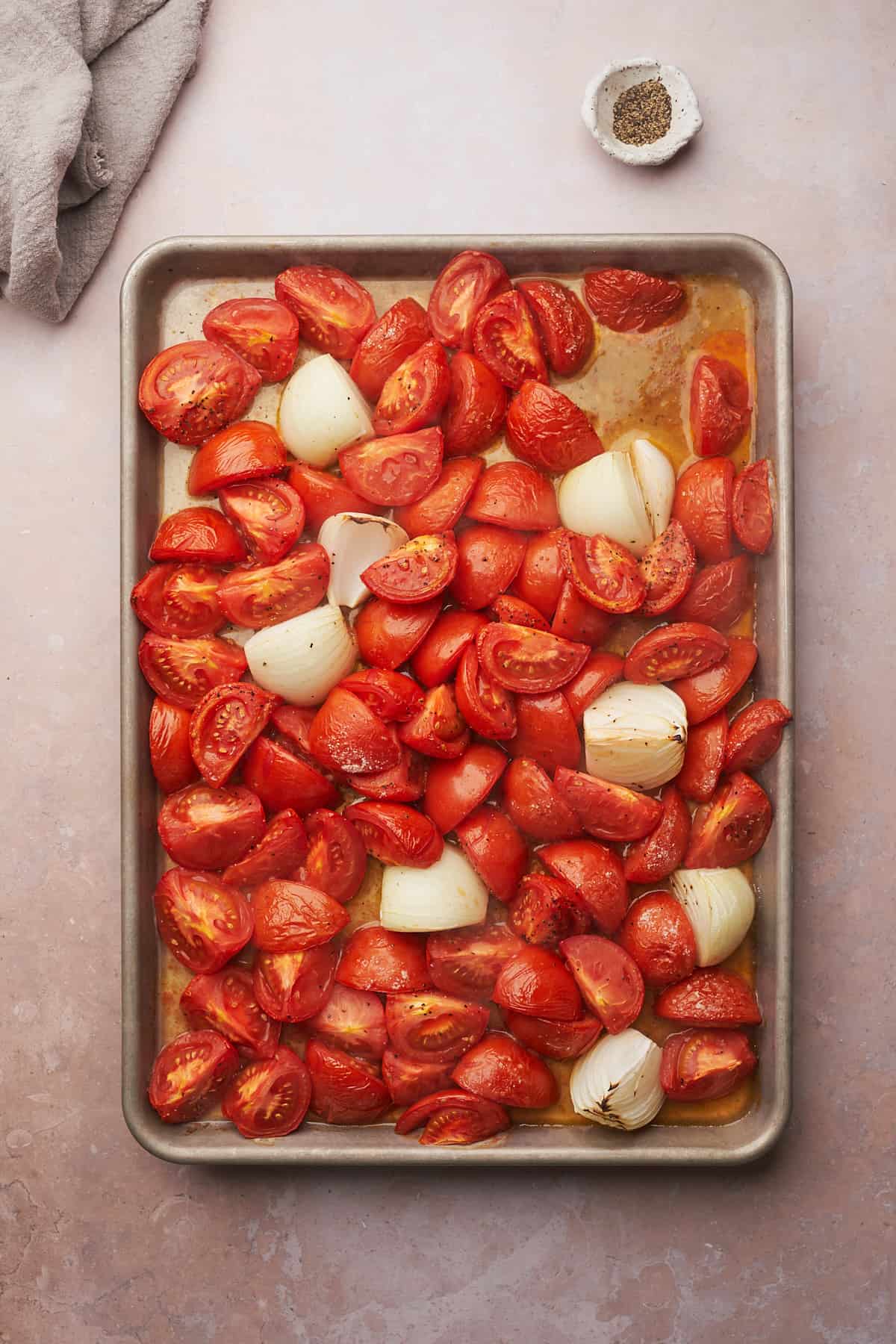 roasted tomatoes and onions on a baking sheet. 