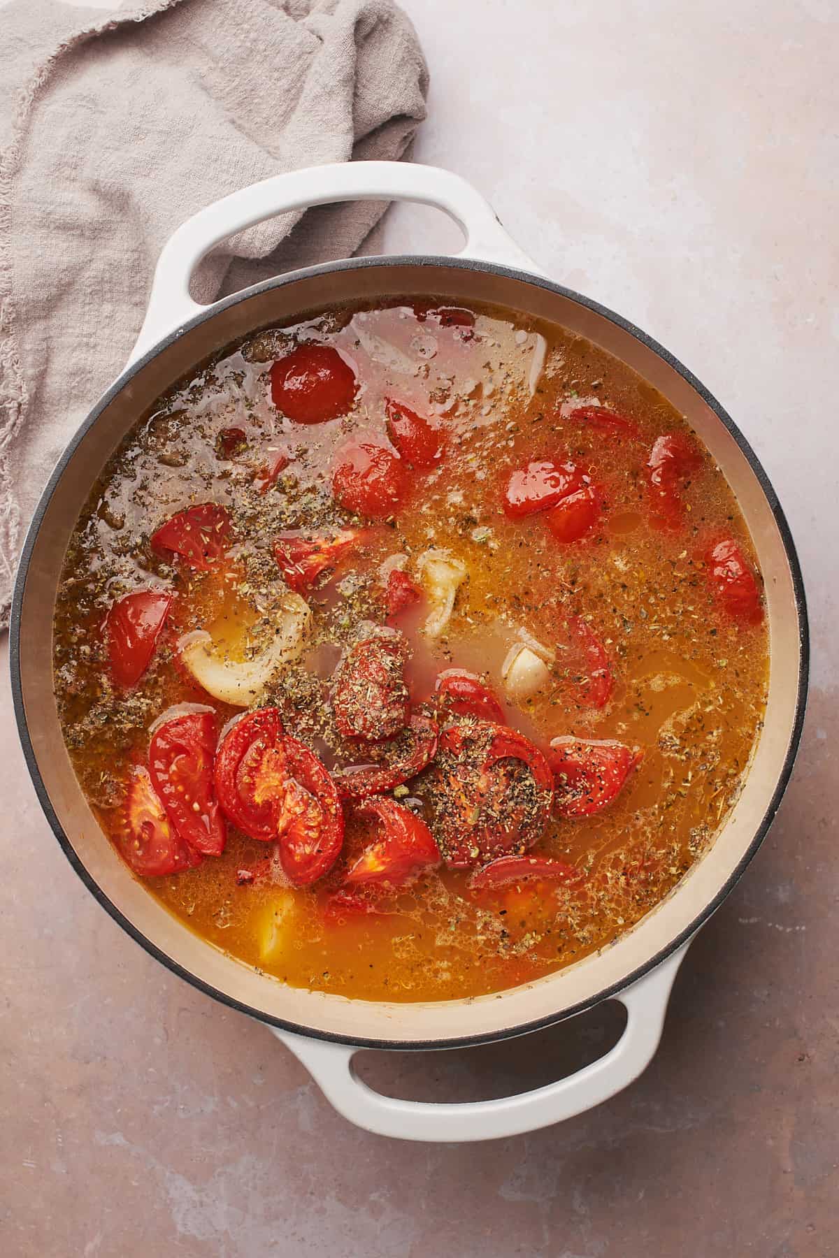 cooked tomatoes and onions in a soup pot with italian seasoning and broth. 