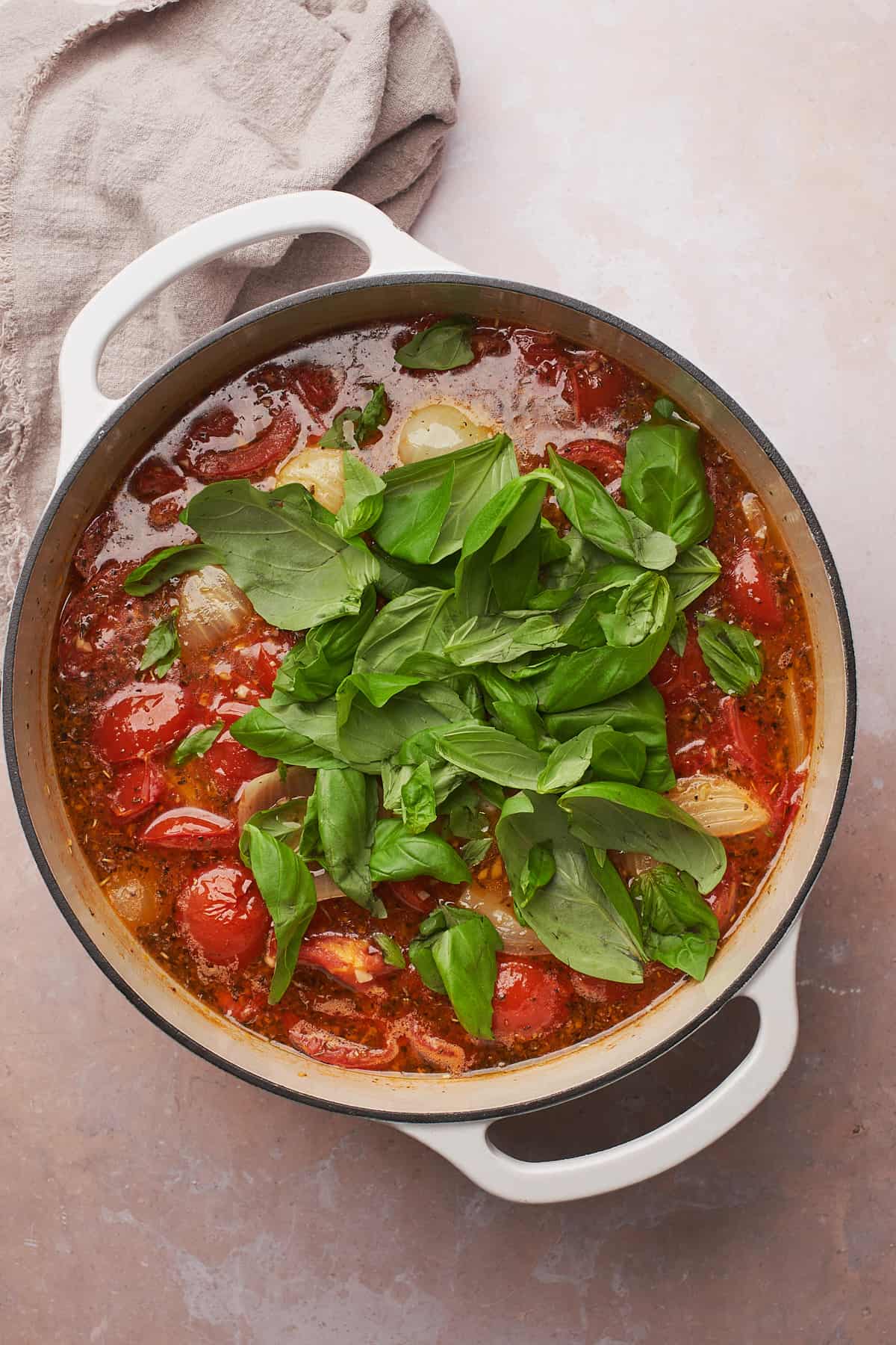 fresh basil in a stockpot of soup with tomatoes.