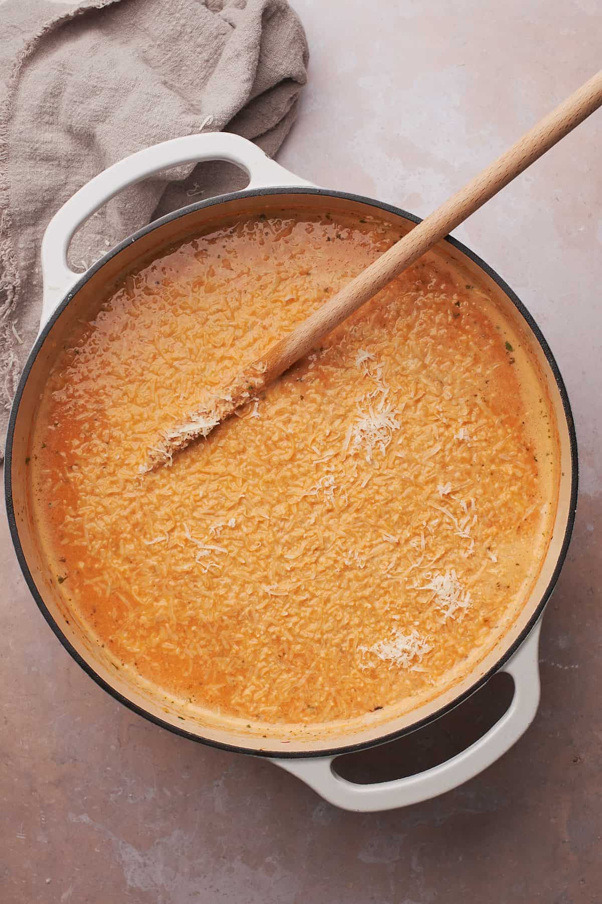 parmesan cheese in a pot of tomato soup with cream. 