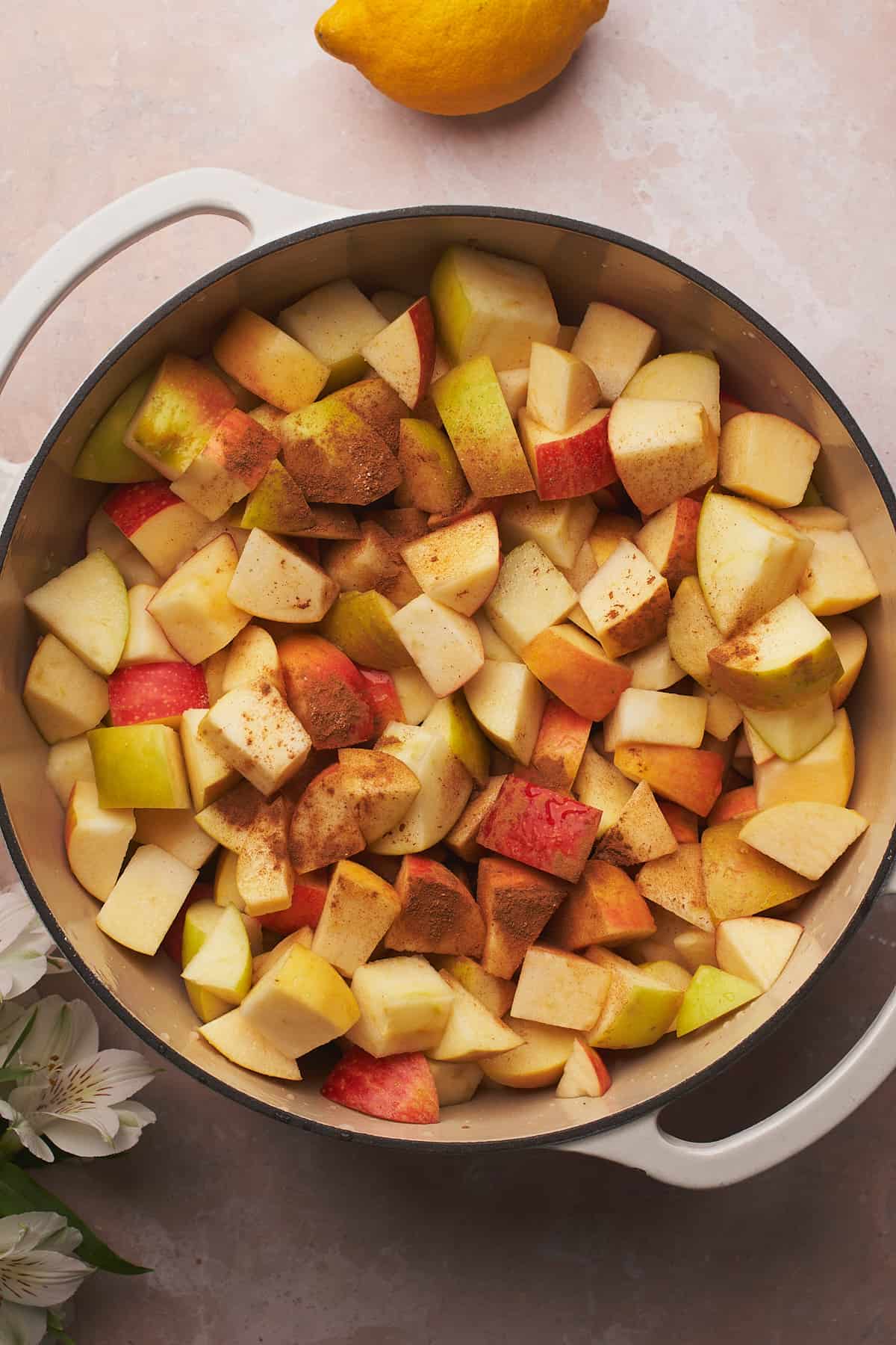 apple pieces in a large dutch oven sprinkled with cinnamon.