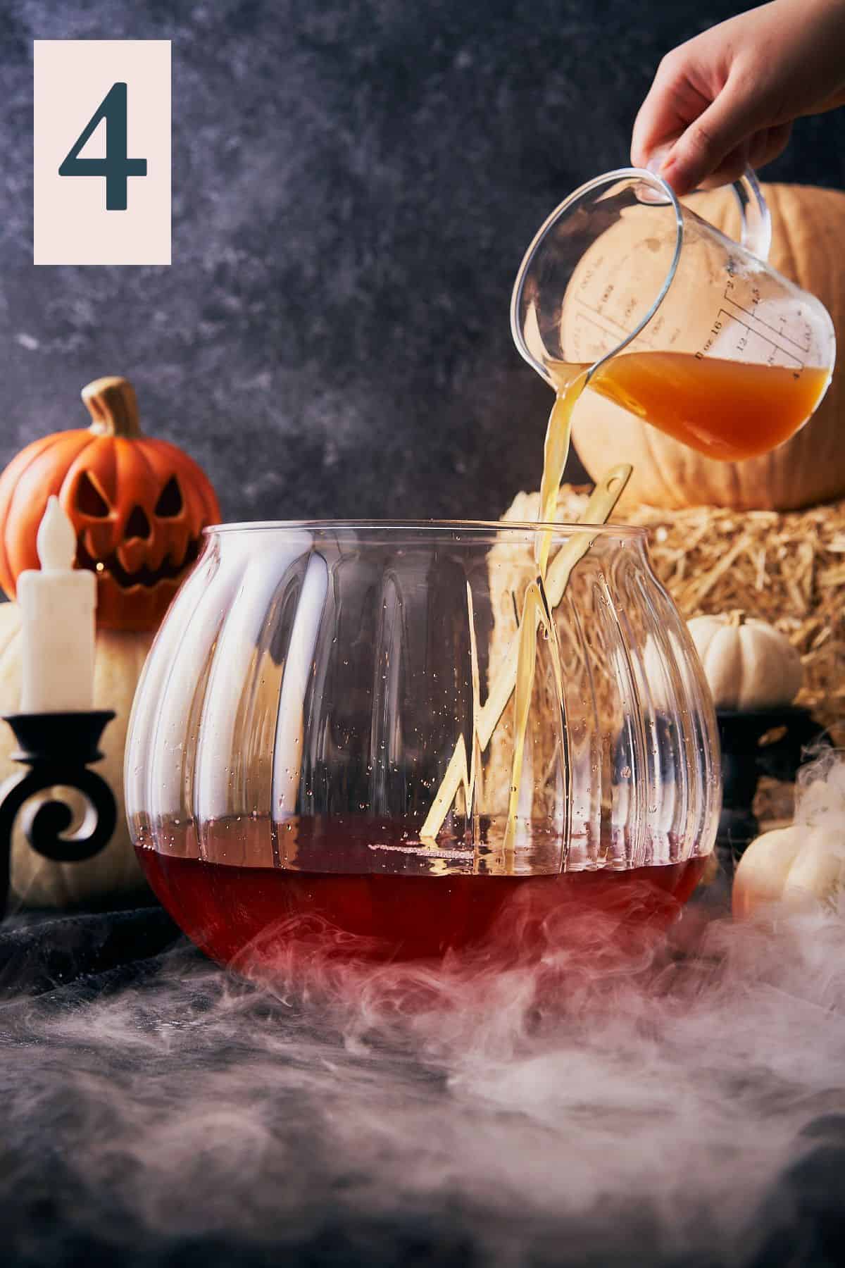 hand pouring in apple cider into a large punch bowl in a spooky halloween scene with a number 4 in the upper left hand corner.