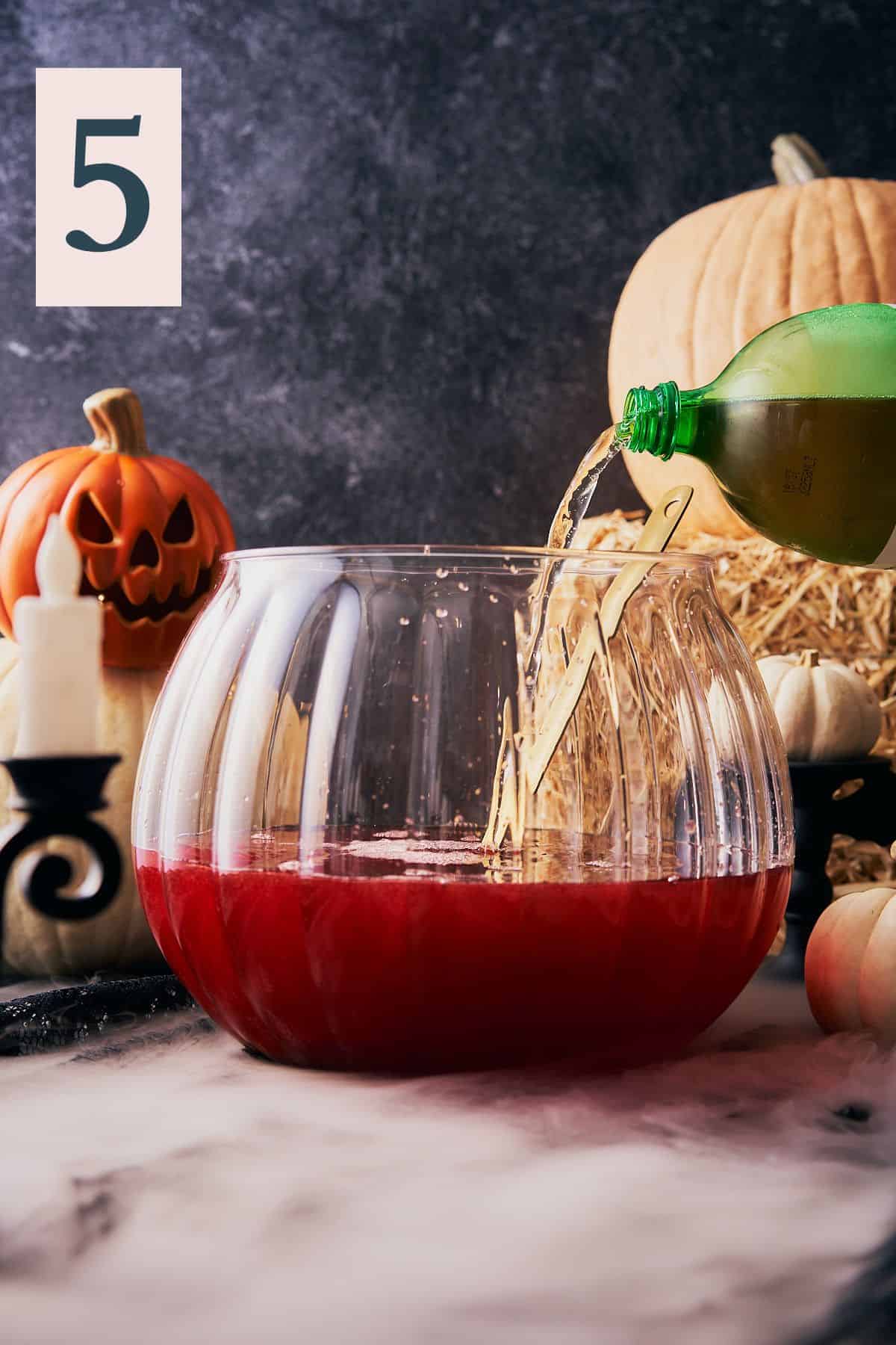 large 2-liter of ginger ale being poured into a spooky punch bowl with a number 5 in the top left hand corner.