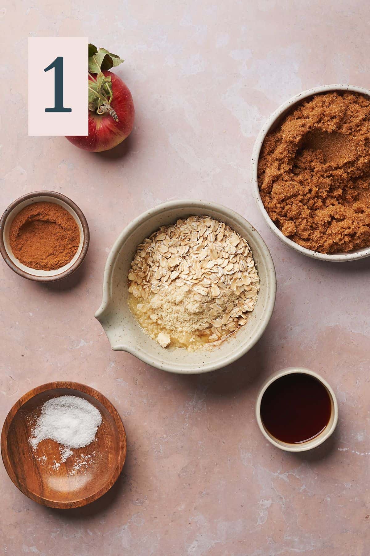 ingredients to make a streusel topping with salt, vanilla extract, apple, and cinnamon surrounding it. 