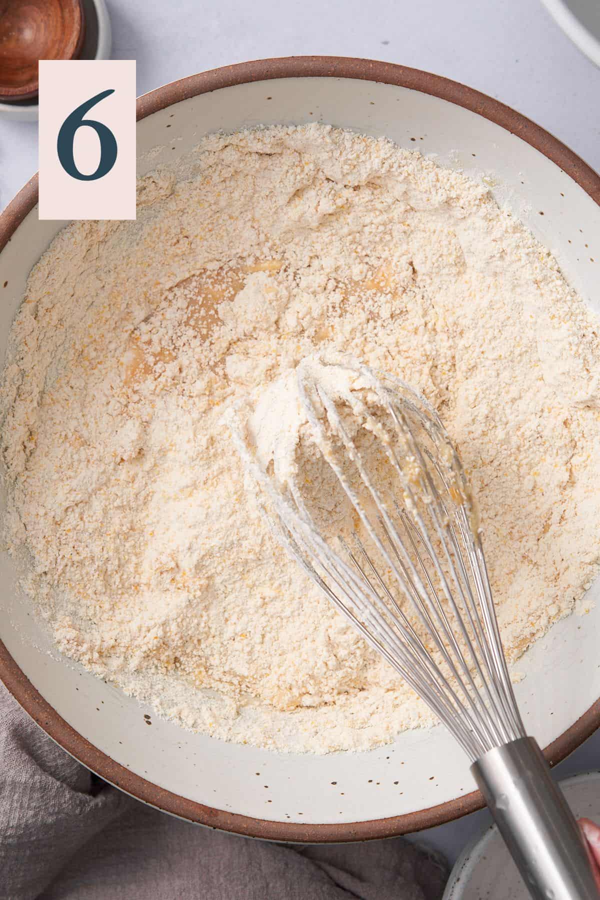 dry ingredients with a whisk in a large bowl getting mixed together. 